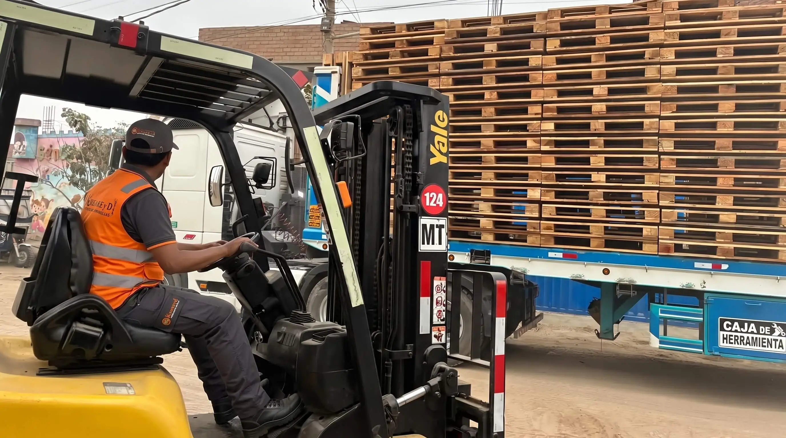 Montacargas cargando parihuelas en un tráiler