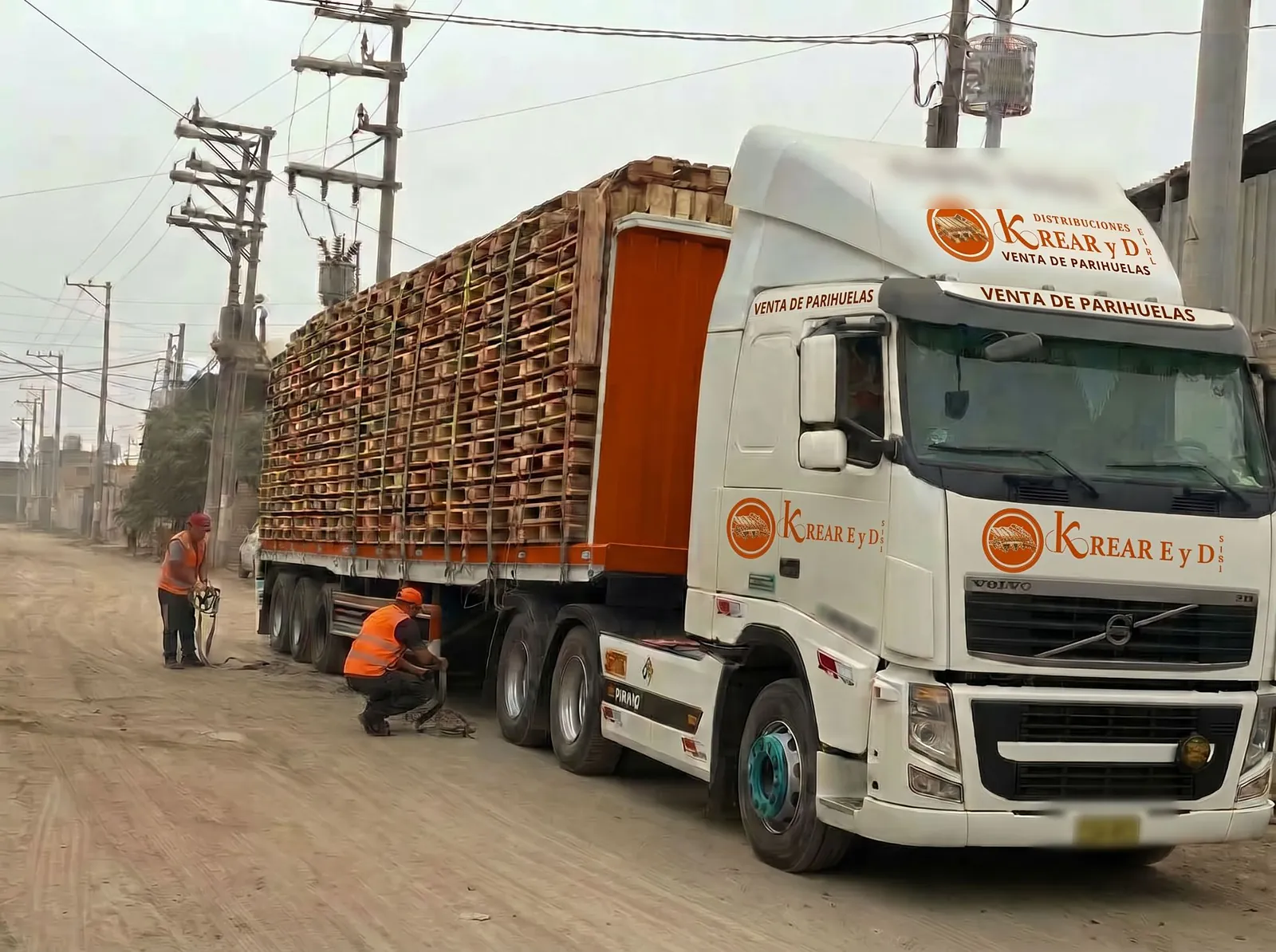 Tráiler cargado con parihuelas de madera, asegurado con fajas para el despacho